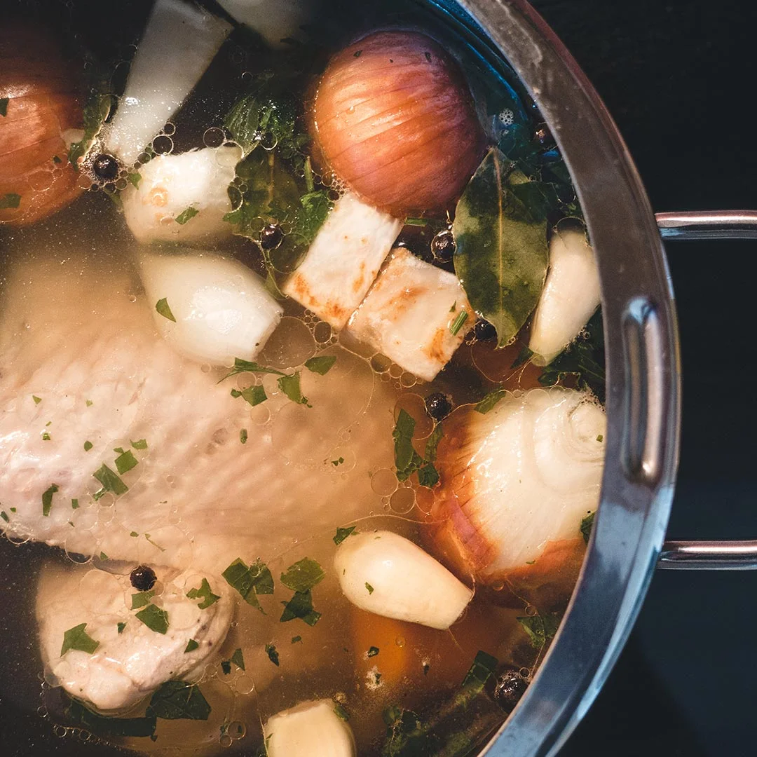 Photo d’un bouillon de viande maison avec légumes, oignon et herbes